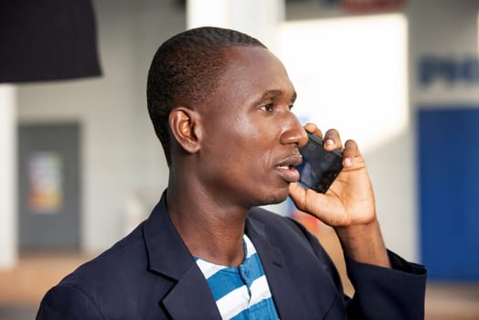 Adult african american businessman talking on a smartphone outdoors in the street