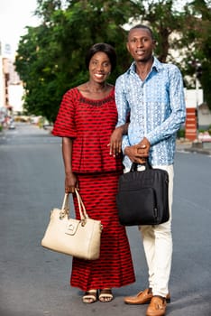 beautiful adult businesswoman dressed in red loincloth walking together with her partner wearing a shirt and jeans on the street being happy
