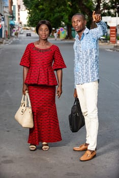 young businessman standing in traditional outdoor outfit showing something to his partner.