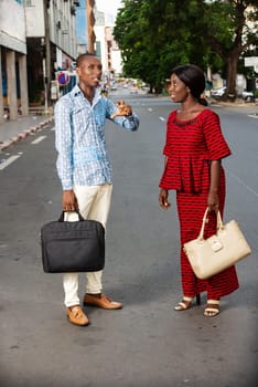 beautiful adult businesswoman dressed in red loincloth walking together with her partner wearing a shirt and jeans on the street being happy