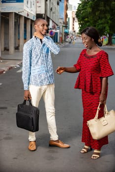 adult businesspeople chatting on the street holding purse each