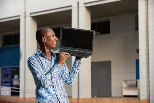 young african american man working standing up while using a computer while smiling