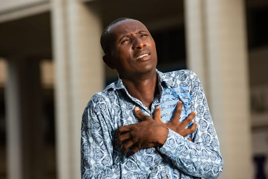 African adult man with health problems and heart pain in the chest