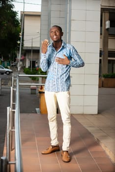 young man standing in full in traditional dress looking up there smiling.