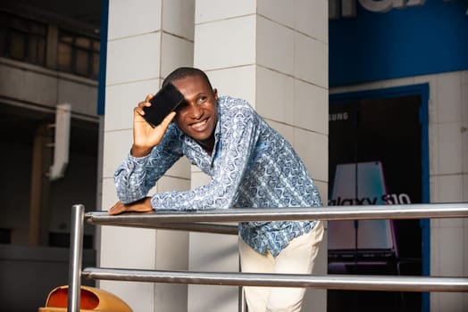 handsome adult african businessman using a mobile phone while being very happy