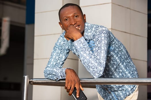 handsome adult african businessman using a mobile phone while being very happy