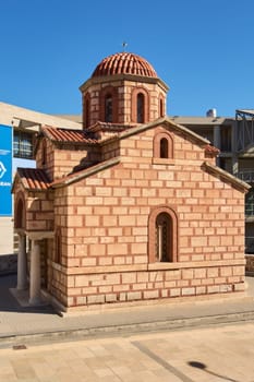A stunning Greek Orthodox church in Heraklion, showcasing a red-tiled dome and arched windows, a perfect example of Byzantine influence.