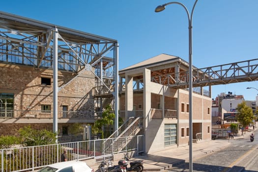 Crete.Greece - april 13, 2025: The Heraklion congress center features bold architectural elements, a fusion of metal and glass, surrounded by urban vibrancy under sunny skies.