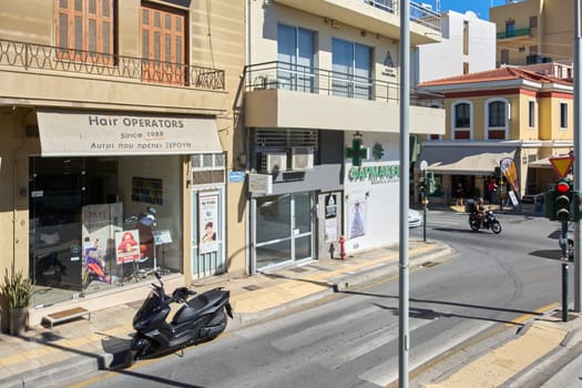 Crete.Greece - april 13, 2025: A charming pharmacy in Heraklion with a green cross symbol and Greek signage, blending traditional architecture with everyday urban life.