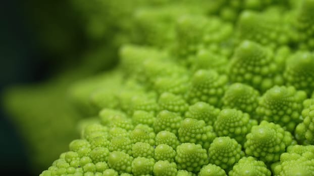 Stunning macro footage of fresh Romanesco cabbage, showcasing intricate fractal patterns, vibrant green color. Healthy eating, organic food, natures geometric beauty. High quality