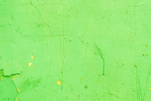 Abandoned, damaged green paint on a wall close-up.