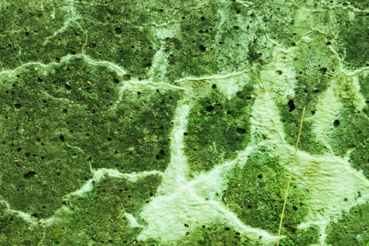 Abandoned wall with damaged green paint, stains, patterns.