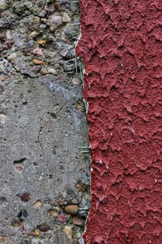 Vertical photo of a concrete wall and red plaster.
