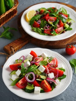 Two plates of fresh salad are presented.