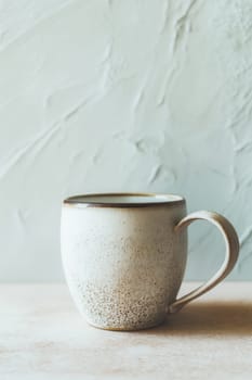 Rustic ceramic mug with a speckled texture and earthy tones on a minimal light background. Perfect for branding mockups, cozy lifestyle scenes, beverage ads, and handmade pottery promotions