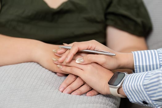A compassionate psychiatrist holds the hands of a distressed client, illustrating the importance of warmth and connection during therapy.