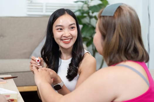 Excited and cheerful, two friends celebrate beauty as they experiment with colors and share smiles during their makeup session.