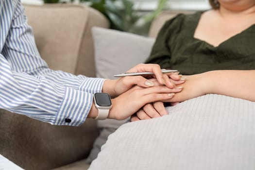 In a supportive environment, a psychiatrist shows compassion by holding the patient's hand, emphasizing the importance of connection during therapy.