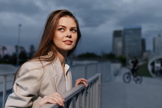 A confident businesswoman in a stylish suit smiles while leaning on a railing in an urban setting. The image conveys professionalism, aspiration, and modernity, ideal for business themes.