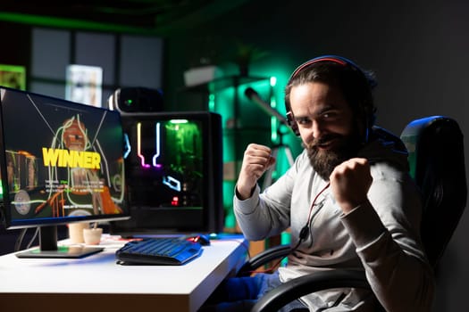 Exulting gamer excited after winning level in first person shooter, killing all enemies. Euphoric player celebrating, manifesting himself after being victorious in videogame