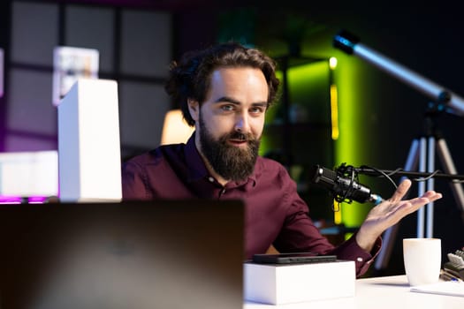 Tech guru filming technology review of newly launched cellphone, doing unboxing video and presenting specifications to viewers. Content creator showing mobile phone box to subscribers