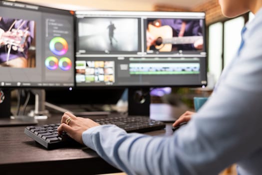 Closeup of video editor with hand on keyboard, using advanced software to refine movie footage. Professional filmmaker working with multi monitor, adjusting film frames to improve cinematic quality.