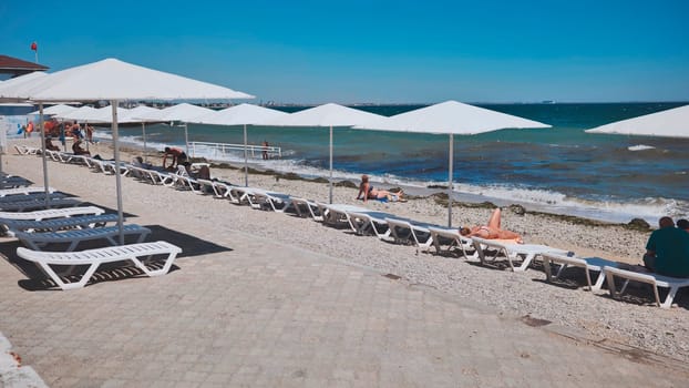 Tourists relaxing on the beach of Feodosia in Crimea.