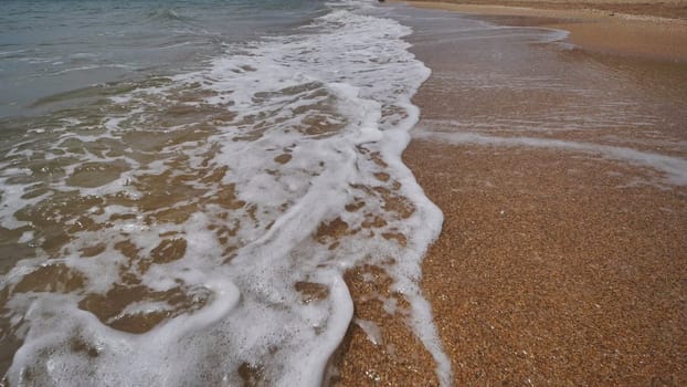 Gentle waves washing the sandy shore of crimea, creating a tranquil scene of natural beauty