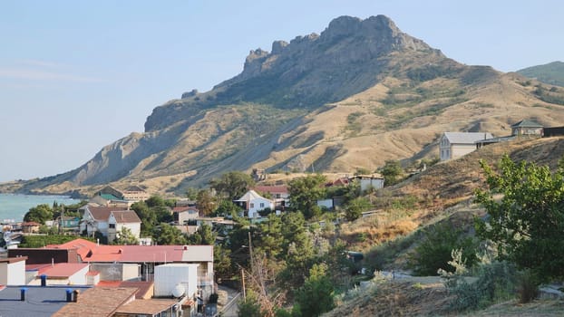 Charming coastal town of ordzhonikidze in crimea, nestled against the black sea, features a majestic mountain in the backdrop