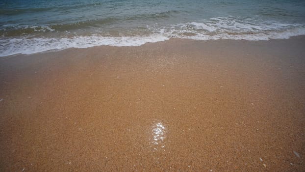 Soft waves gently washing golden sand on a beach in Crimea, creating a tranquil and relaxing scene