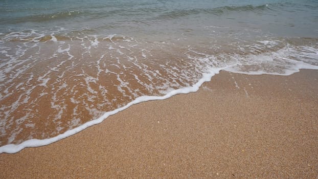 Gentle waves caressing golden crimean shoreline, soft sunlight gleaming on smooth beach surface, tranquil coastal scene