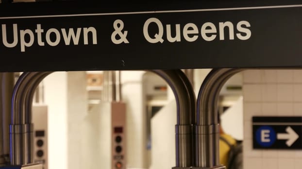 New York City, United States - 31 Aug 2023: Subway station interior. Text sign: Uptown, Queens. Manhattan underground metropolitan. Metro transport navigation. Public passenger railway. Entrance, exit