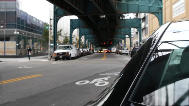 New York City, United States - 31 Aug 2023: Elevated subway above street. Metropolitan bridge over road, Queens. Long Island metro line, Court Square. Cars under metallic railway track. NYC urban life