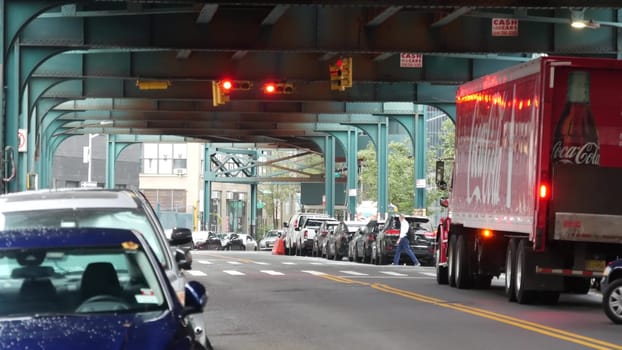New York City, United States - 13 Sept 2023: Coca-cola truck, elevated subway above street. Metropolitan bridge over road, Queens. Long Island metro line. Coca cola delivery, Coke lorry, railway track