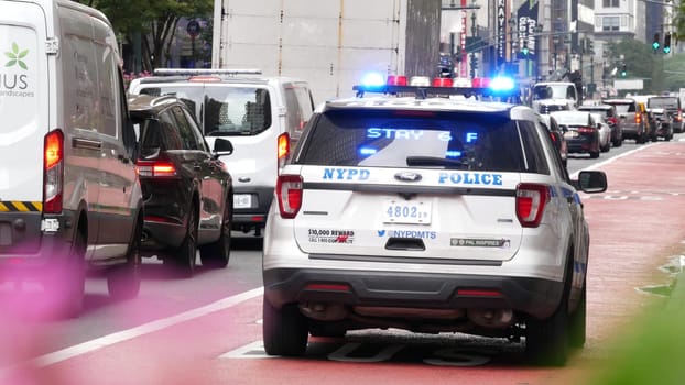 New York City, United States - 29 Aug 2023: Police patrol car, USA NYPD 911 vehicle, Manhattan Midtown, busy 34th street. American cop auto siren on avenue, urban traffic scene, Herald square in NYC.