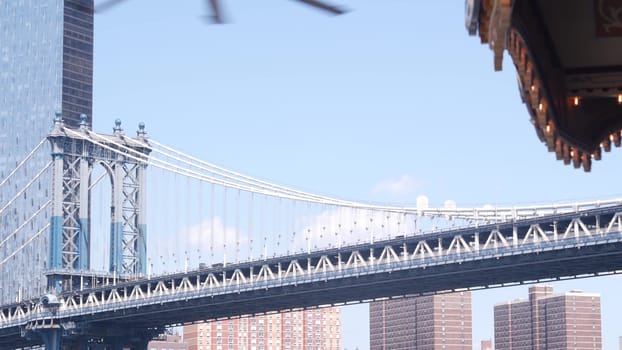 New York City, United States - 30 Aug 2023: Manhattan Bridge to Brooklyn Dumbo. Retro vintage carousel, USA travel destination, tourist landmark. Cable-stayed bridge and old merry-go-round.