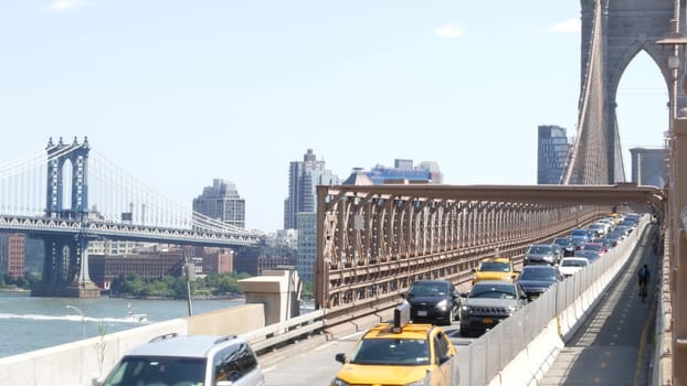 New York City, United States - 3 Sept 2023: Cars on Brooklyn Bridge, Manhattan Bridge view. Yellow taxi cab, rush hour road traffic jam and architecture. Iconic landmark on East River. Travel USA.