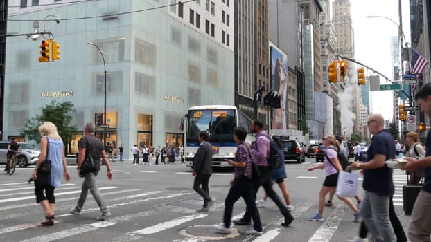 New York City, United States - 11 Sept 2023: Manhattan Midtown street, Fifth 5 avenue, USA. American urban Road traffic, crossroad intersection. People pedestrians on zebra crosswalk. Shopping store.
