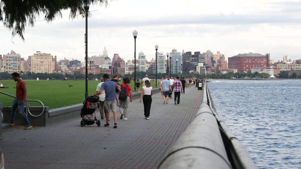 New York City, United States - 11 Sept 2023: Waterfront skyline, Manhattan Midtown riverfront buildings. Waterside cityscape from Pier A Park, Hoboken New Jersey. People walking, grass lawn. Hudson.