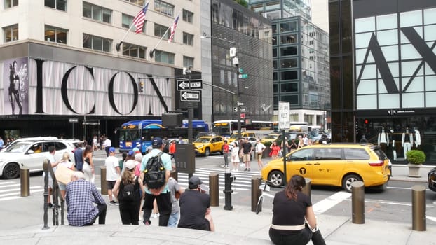 New York City, United States - 11 Sept 2023: Manhattan Midtown street, Fifth 5 avenue. American urban road car traffic, crossroad intersection. Yellow taxi in USA. People pedestrians. Shopping stores.