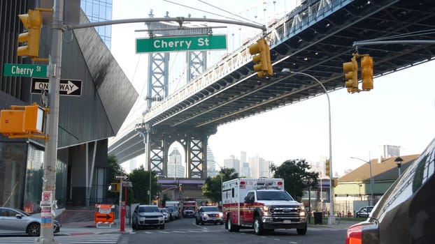 New York City, United States - 7 Sept 2023: NYFD Ambulance medical emergency, fire department paramedic truck. Manhattan bridge. Police patrol car, USA NYPD 911 vehicle on street. American cop siren.