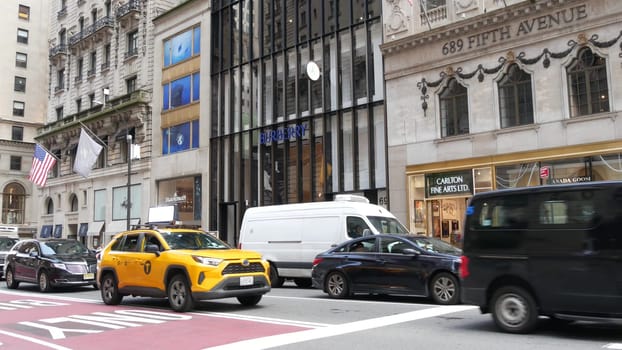 New York City, United States - 11 Sept 2023: Manhattan Midtown street, 5th Fifth 5 avenue. American urban road car traffic. Yellow taxi cab in USA. FDNY emergency ambulance paramedic 911 truck. Stores