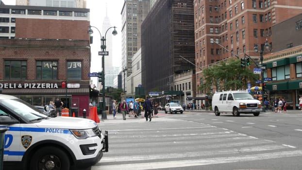 New York City, United States - 29 Aug 2023: Police patrol car, USA NYPD 911, Manhattan Midtown 34th street. American cop auto, 9 avenue. Urban road traffic. People, Empire State Building, New Yorker.