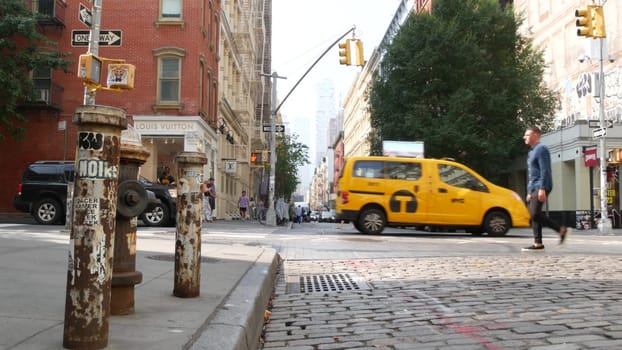 New York City, United States - 8 Sept 2023: Manhattan Soho fashion district near Broadway street. USA urban building facade, old classic american architecture. Shopping in NYC. People, yellow taxi cab