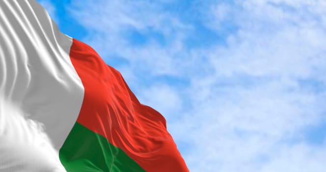 3D render of the national flag of Madagascar fluttering in the wind, symbolizing pride, independence, and African identity under a bright sky.