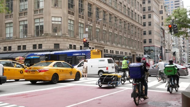 New York City, United States - 11 Sept 2023: Manhattan Midtown street, Fifth 5 avenue. American urban road car traffic, crossroad intersection. Yellow taxi cab in USA. People pedestrians go shopping.