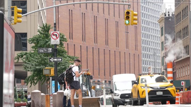 New York City, United States - 9 Sept 2023: Manhattan Downtown Financial District Water street crossroad intersection. Urban road car traffic. Yellow taxi, people. Hot smoke stack, steam pipe. USA