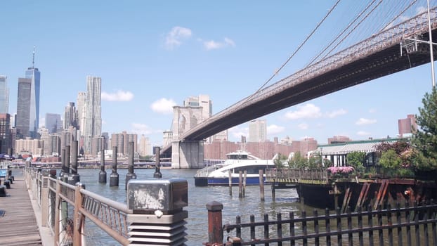 New York City, United States - 30 Aug 2023: Brooklyn Bridge, Manhattan downtown skyline, financial district waterfront cityscape. World Trade Center skyscraper view. Dumbo, East river ferry boat pier.
