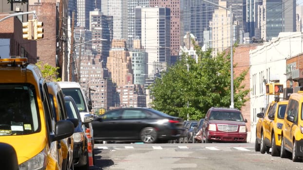New York City, United States - 1 Sept 2023: Row of yellow taxi cars on street, Queens. Taxi cab on avenue, Long Island. Medallion taxicab. Manhattan Midtown urban skyline cityscape. High-rise building