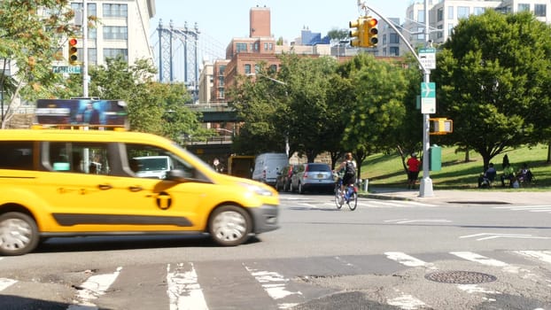 New York City, United States - 7 Sept 2023: Manhattan Bridge, Brooklyn Dumbo. Cars on road, traffic on Washington street crossroad. NYC yellow taxi cab. People walking, pedestrians and zebra crosswalk